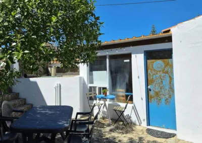 Outdoor patio with hand-painted blue door at Soul Spot Surf Camp, Praia Grande
