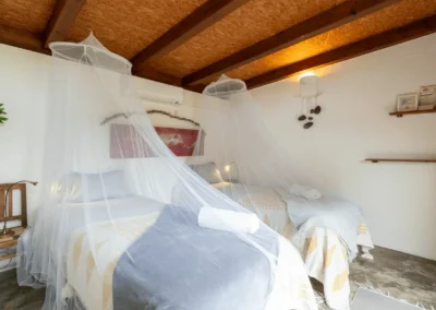 Twin beds with mosquito net canopies at Soul Spot Surf Camp, Sintra